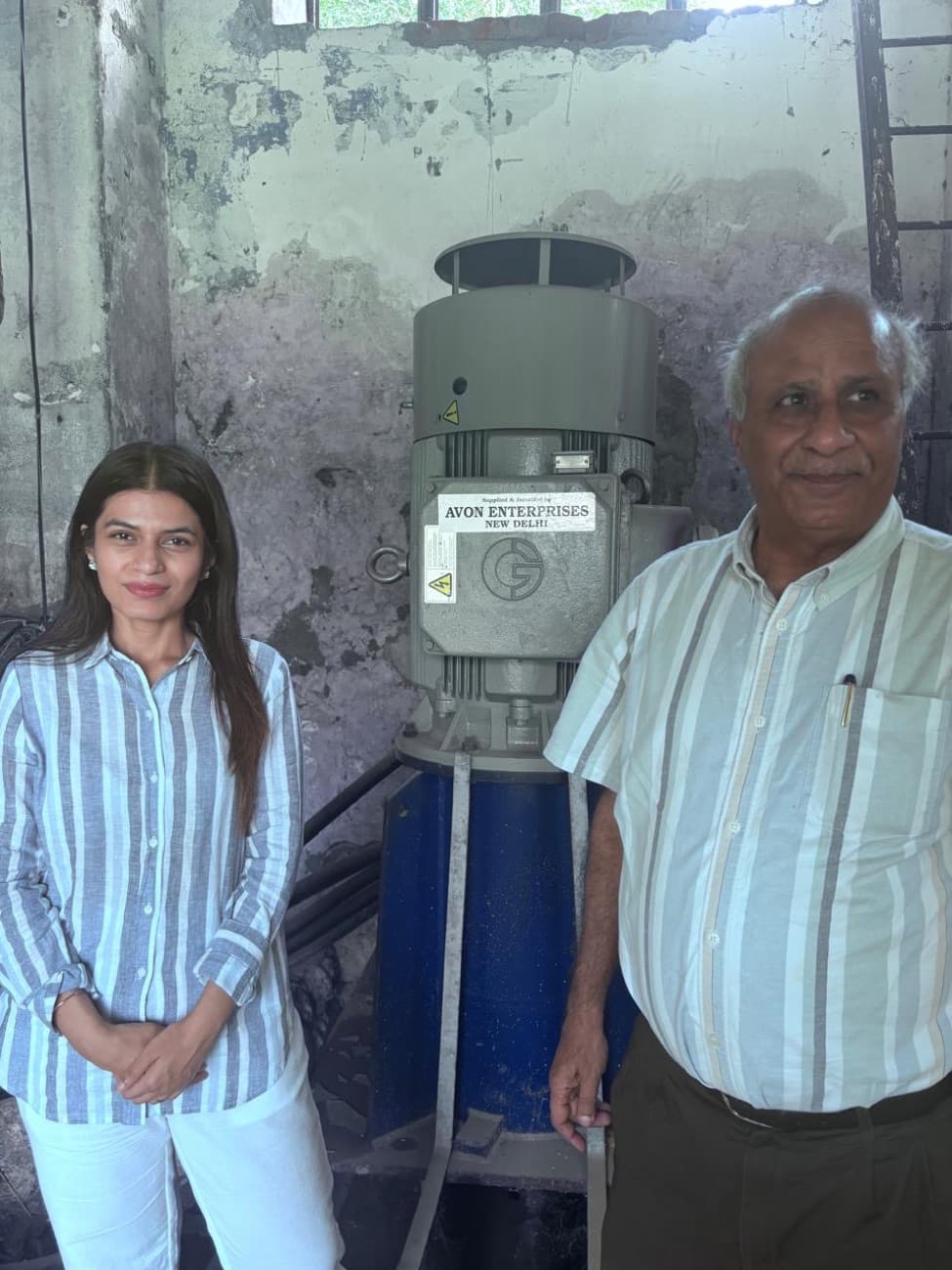 Disha Kapoor beside a pump motor during a facility inspection